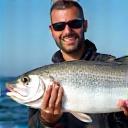 Cliente soddisfatto Alessandro G. con una spigola catturata